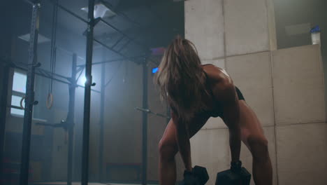 A-woman-performs-push-UPS-with-dumbbells.-burpee-with-weight.-The-jerk-of-the-dumbbells-over-your-head.-A-woman-trains-with-a-heavy-weight.